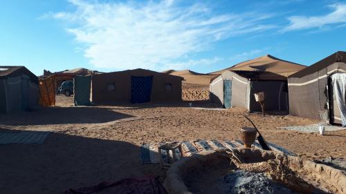 a group of tents in the middle of a desert at Auberge la Palmeraie in Mhamid