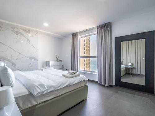 een slaapkamer met een groot bed en een grote spiegel bij Luxury Waterfront Apartment with Beach Access in Dubai