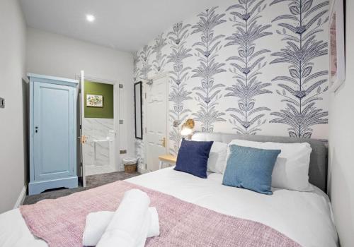 a bedroom with a large white bed with blue pillows at The Narrow House - Free Parking By My Getaways in Brighton & Hove