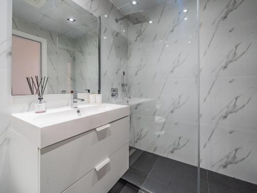 杜拜的住宿－Luxury Waterfront Apartment with Beach Access，白色的浴室设有水槽和淋浴。