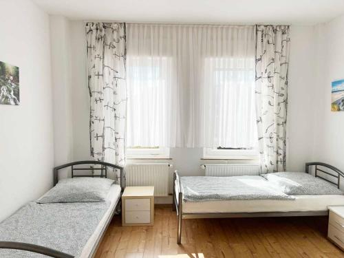 a bedroom with two beds and a window at Work and Stay Troisdorf in Troisdorf