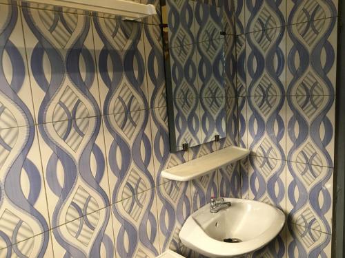 a bathroom with a sink and a mirror at Residence MaryHouse - Free Breakfast and Taxi From Airport in Cotonou