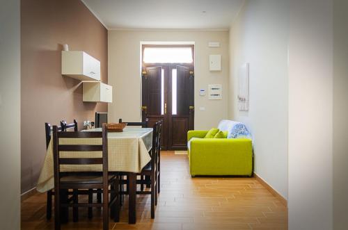a dining room with a table and a green chair at La casa di Bice in Cassibile