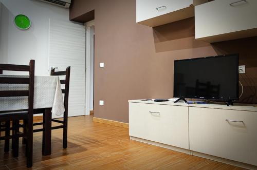 a living room with a television and a table with chairs at La casa di Bice in Cassibile