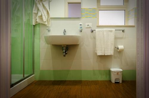 a bathroom with a sink and green and white tiles at La casa di Bice in Cassibile
