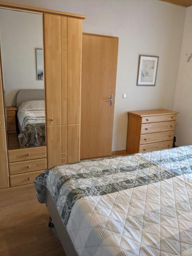 a bedroom with a bed and a closet and a dresser at Ferienwohnung Bruss in Saarlouis