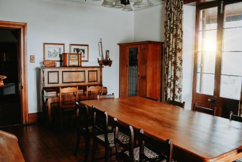 een eetkamer met een houten tafel en stoelen bij Swartvlei Guest Farm in Sedgefield