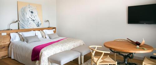 a bedroom with a bed and a table and a tv at La Garriga de Castelladral in Castelladral