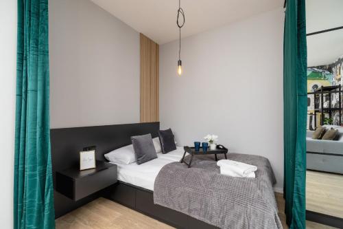 a bedroom with a bed and a table at Kraków Rynek Podgórski Apartments by Renters in Krakow