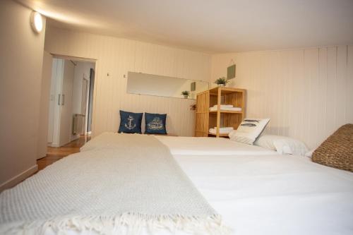 2 weiße Betten in einem Zimmer mit in der Unterkunft LA MARINA amplio apartamento en pleno centro de Hondarribia in Hondarribia