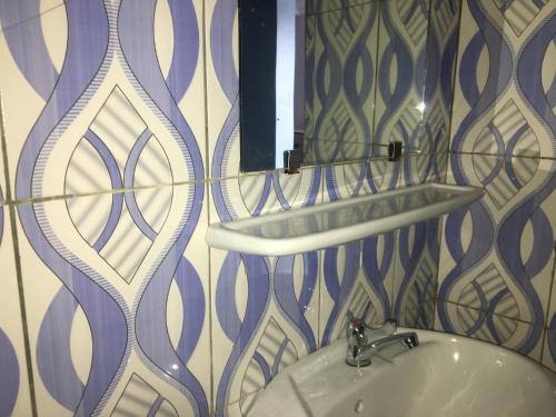a bathroom with a sink and a mirror at Residence MaryHouse - Free Breakfast and Taxi From Airport in Cotonou