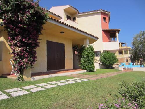a villa with a garden and a house at Vallemare Residence e Studios in Baja Sardinia