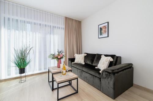 a living room with a black couch and a table at Modern Apartments Śródmiescie Kraków by Renters in Krakow