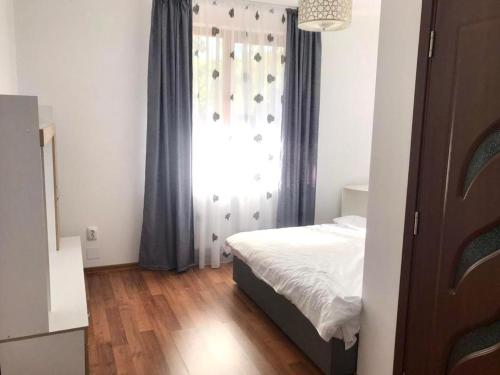 um pequeno quarto com uma cama e uma janela em Casa Luna em Cluj-Napoca