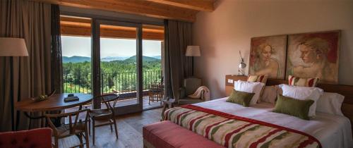 a bedroom with a bed and a table and a balcony at La Garriga de Castelladral in Castelladral