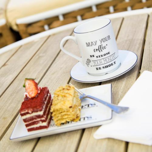 a plate of cake and a cup of coffee on a table at Azka Hotel in Bodrum City