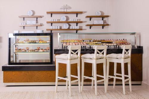 a bakery with three white stools in front of a counter at Azka Hotel in Bodrum City