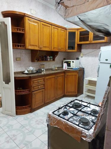 La cuisine est équipée de placards en bois et d'un four avec plaques de cuisson. dans l'établissement 1 bedroom apartment in the heart of Cairo , just 15 minutes from the airport, au Caire