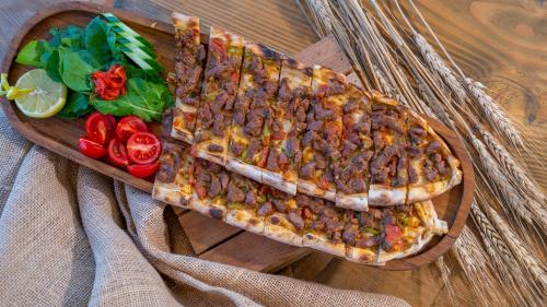 a plate of food with a pizza and vegetables on a table at Azka Hotel in Bodrum City