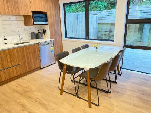 a kitchen with a table and chairs in a kitchen at NO PARTY ALLOWED, Entire Brand New 3 bedroom townhouse, free unlimited fibre wifi and free parking in Wellington