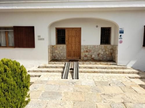 un edificio con una puerta de madera y algunas escaleras en Villa Silenci - Sa Pobla, en Sa Pobla