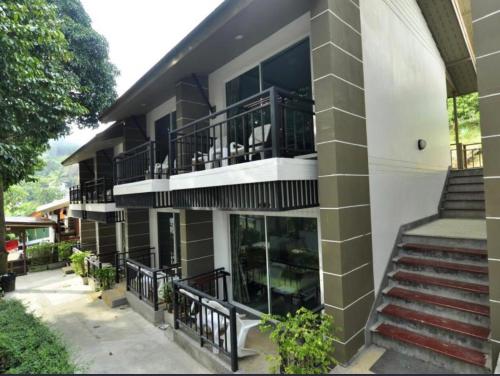 a building with balconies and stairs in front of it at PP Midnight Hotel in Phi Phi Don