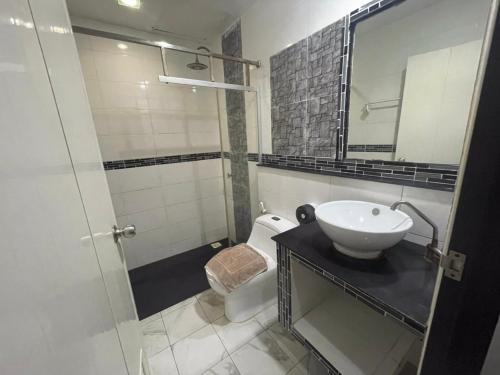 y baño con lavabo, aseo y espejo. en PP Midnight Hotel, en Islas Phi Phi