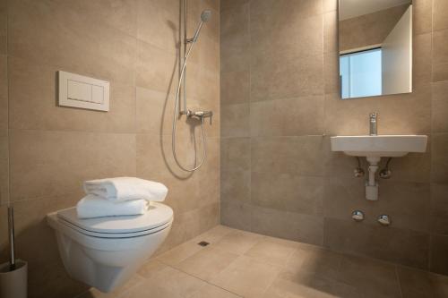 een badkamer met een douche, een toilet en een wastafel bij Hotel Perron 10 in Winterthur