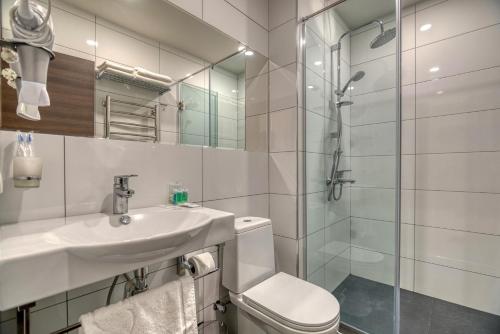 uma casa de banho com um lavatório e um chuveiro em Orbeli Hotel Yerevan em Yerevan