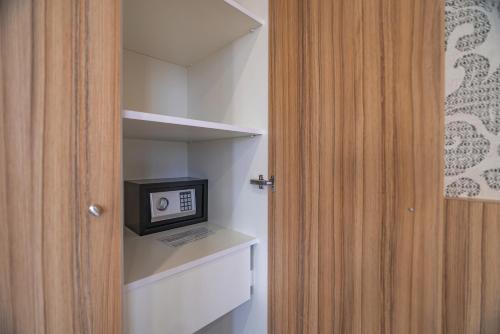 a door to a room with a small television on a shelf at Orbeli Hotel Yerevan in Yerevan