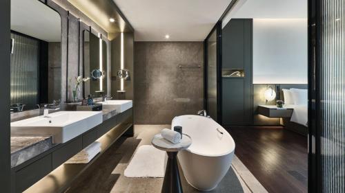 a bathroom with two sinks and a large tub at Crowne Plaza Wuhan Development Zone by IHG in Wuhan