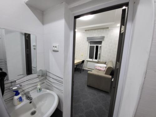 uma casa de banho com um lavatório e um quarto com um sofá em Shahriston GH em Tashkent