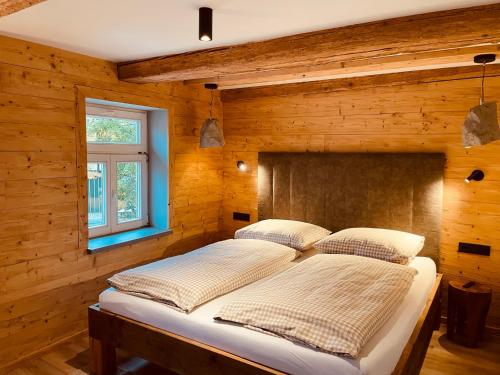 1 dormitorio con 1 cama en una pared de madera en FourElements, en Wernigerode