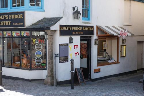 a group of shops on a street in a city at The Old Hay Barn, Croft Hooper in Ludgvan