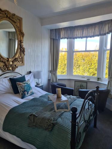 a bedroom with a large bed and a mirror at The Ocean Guest House in Weymouth
