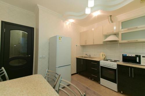 una cucina con frigorifero bianco e tavolo con sedie di Warm apartment ad Affligem