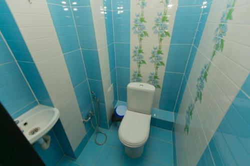 a blue tiled bathroom with a toilet and a sink at Warm apartment in Affligem