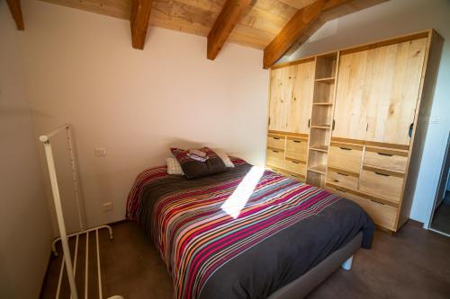 um quarto com uma cama num quarto com tectos em madeira em Appartement de 2 chambres avec balcon amenage a Saint Come d'Oltc em Saint-Côme-dʼOlt
