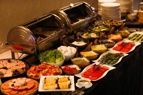 a buffet with many different types of food on a table at Urban Park Hotels in Tbilisi City