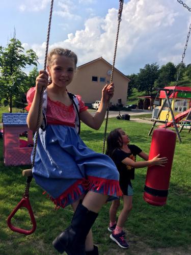 two young girls playing on swings in a park at Jazdecký areál Budička in Trnie