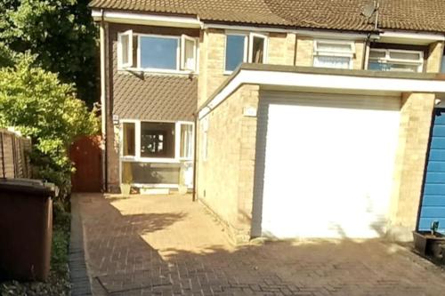 een witte garagedeur aan de zijkant van een huis bij Peaceful 4 bedroom house with free parking in Frimley