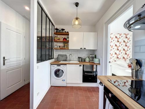 a kitchen with a washer and dryer in a room at Studio LE VINTAGE - Maison 1911 - confort & prestige in Gien