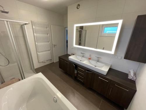 a bathroom with a tub and a sink and a mirror at Penthouse Wohnung am Radweg mit Dachterasse in Waidhofen an der Thaya