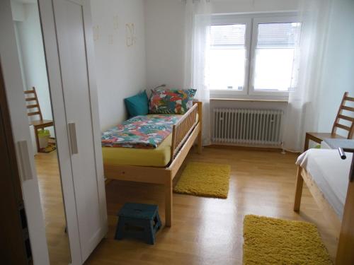 um pequeno quarto com um berço e uma janela em Lissy`s Ferienwohnung em Bad Königshofen im Grabfeld