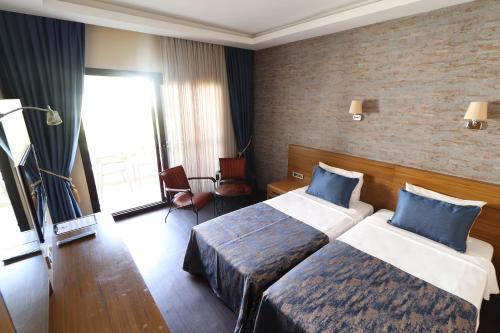 a hotel room with two beds with blue pillows at Azka Hotel in Bodrum City