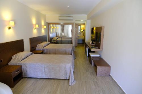 a hotel room with two beds and a television at Azka Hotel in Bodrum City