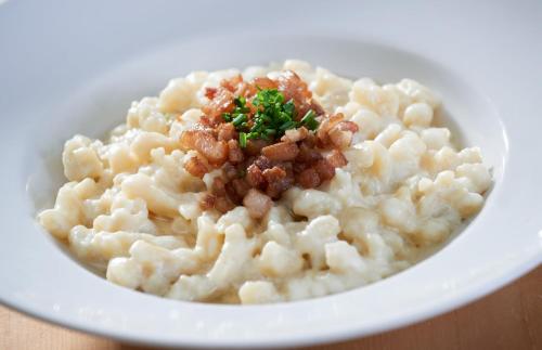 a white bowl of macaroni and cheese with a garnishment at Wellness Hotel Florián České Žleby in Stožec