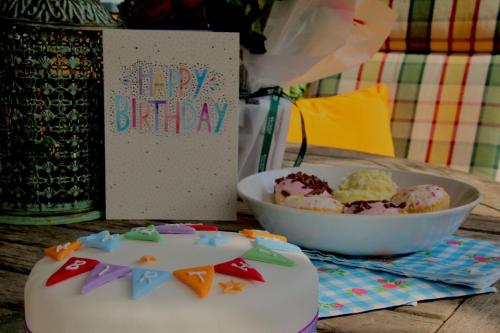 a table with a birthday cake and a bowl of desserts at Stamford Meadows Glamping with Private Hot Tubs in Stamford
