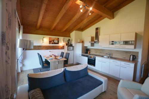 eine Küche und ein Wohnzimmer mit einem Sofa und einem Tisch in der Unterkunft Ferienappartement Rettenschöss in Rettenschöss