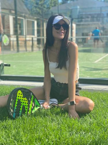 a woman sitting on the grass with a skateboard at Iris Hotels Resort in Vorzelʼ
